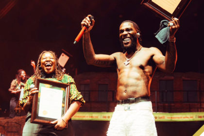 Burna Boy being presented with a plaque by the Boston City Council at the TD Gardens Arena