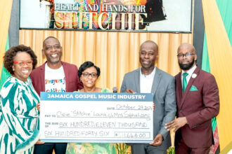 Members of the Jamaica Gospel Music Industry hand over check to Lt. Stitchie's wife, Sophia Laing (center)