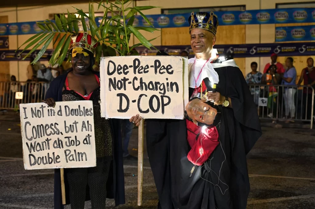 King and Queen of the Down Town J’ouvert winners Richard Montano, right with “Dee-Pee-Pee not charging D-COP” and Queen Laverne Smith with “Not in the Doubles Comess, But a want a job at Double Palm” at South Quay last yesterday. Photo: Curtis Chase