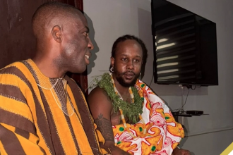 Popcaan in conversation with a Ghanaian official